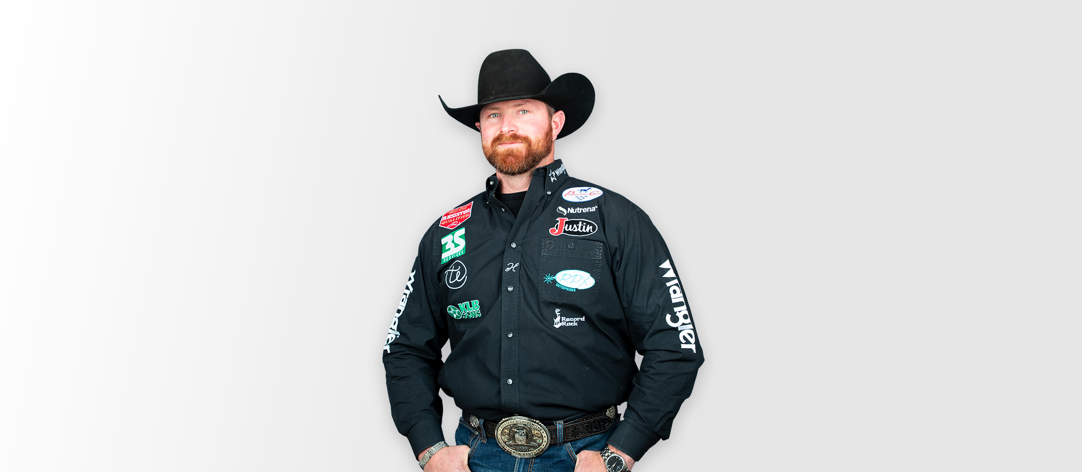 Man wearing a black cowboy hat and black western shirt smiling